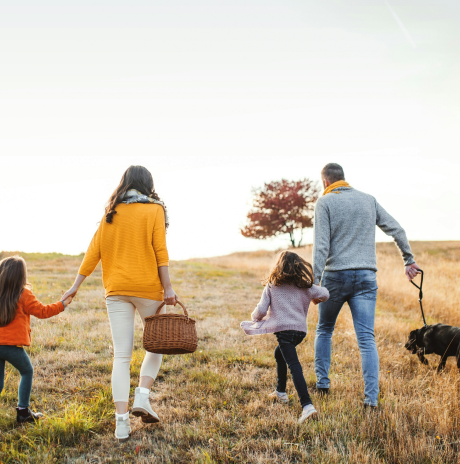 Family walking outdoors with their dog
